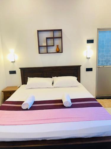 a bedroom with a large bed with two pillows at Samara Beach Stay in Weligama