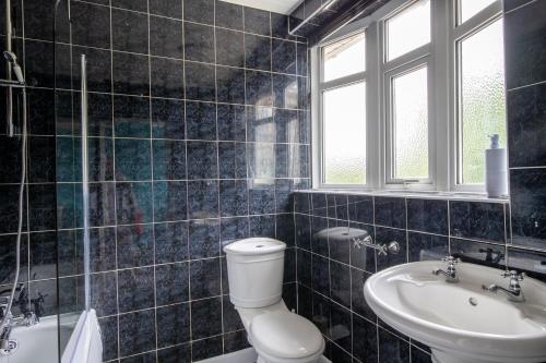 a bathroom with a toilet and a sink at 40 Percent Off Monthly, Large House, Free Parking in Sheldon