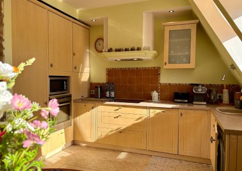 a kitchen with wooden cabinets and a sink at Apartament Pers - przytulny, klimatyzowany, z kominkiem i bezpłatnym parkingiem in Szczawno-Zdrój