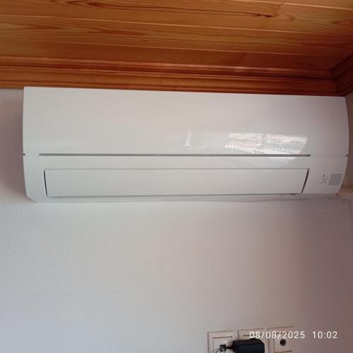 a white microwave oven sitting on top of a refrigerator at Kostis Central Loft in Metsovo