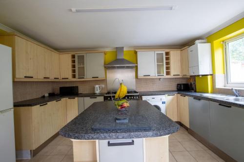 a kitchen with a island with a bowl of fruit on it at 40 Percent Off Monthly, Large House, Free Parking in Sheldon