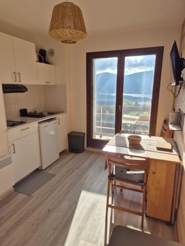 a kitchen with a table and a large window at Studio cabine Les Angles - Soleil et Montagne in Les Angles