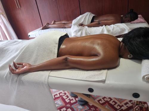 two women laying on beds in a room at La Exotica Lodge & Spa in Rustenburg