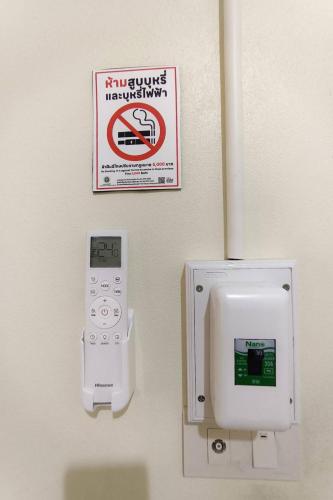 a bathroom with a thermometer and a no smoking sign at JT Place Buriram in Buriram