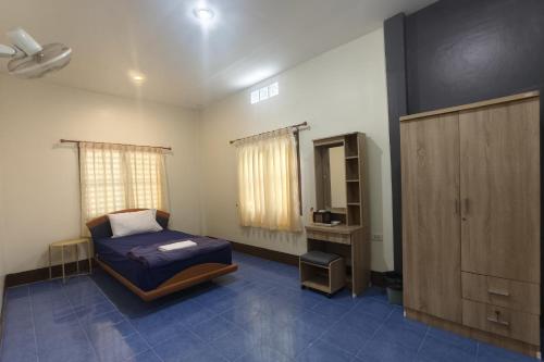 a bedroom with a bed and a cabinet in it at JT Place Buriram in Buriram