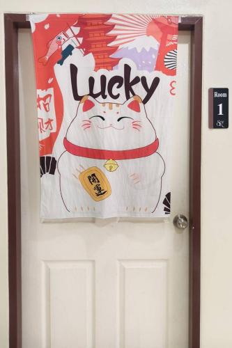 a door with a hello kitty banner on it at JT Place Buriram in Buriram