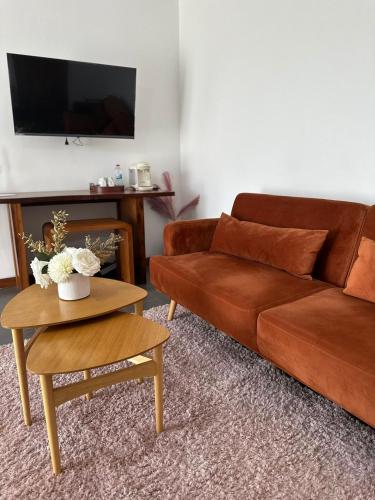 a living room with a brown couch and a table at Tia Vahine in Ivato