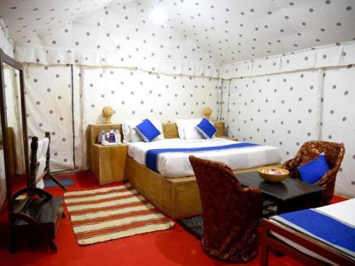 a bedroom with a bed and a table and a chair at desert Galaxy Camp Jaisalmer in Jaisalmer