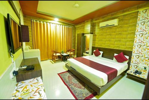 a bedroom with a bed and a desk and a television at Avexia Elite Resort & Spa Udaipur in Guman