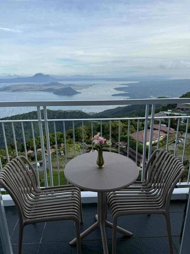 uma mesa e 2 cadeiras numa varanda com vista em Taal Lake View Condo in Tagaytay em Kaybagal