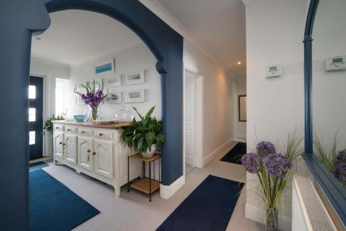 an archway in a bathroom with a sink and flowers at Serendipity - Sweet home with sweeping sea views in Isle of Wight
