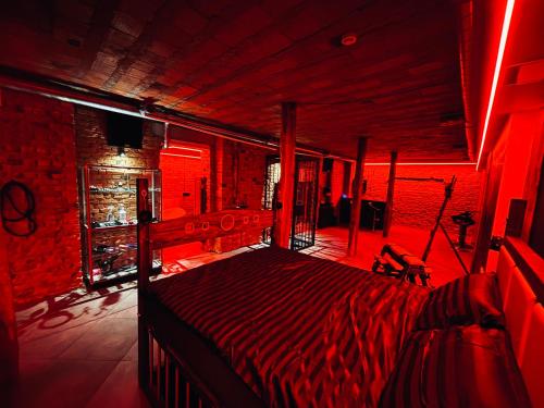 Un dormitorio con una cama en una habitación roja. en 69 apartaments BDSM, en Panevėžys