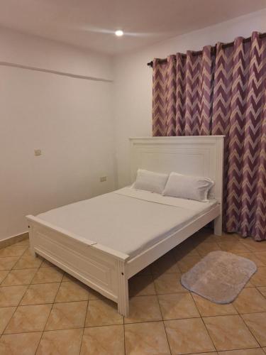a white bed in a room with at Diani place in Ukunda