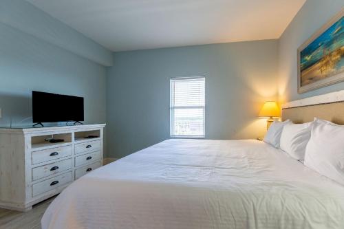 a bedroom with a white bed and a flat screen tv at Laketown Wharf Condo beach view in Panama City Beach