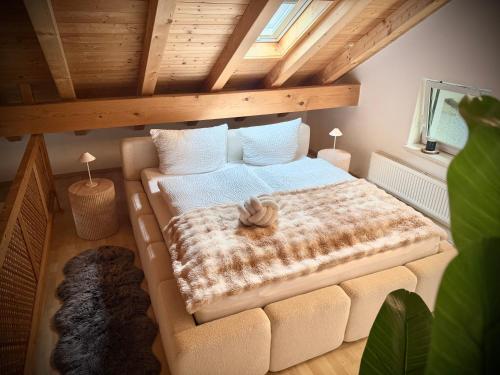 an attic bedroom with a bed and a couch at Stilvolle Ferienwohnung in Immenstadt zentral & mit Parkplatz in Immenstadt im Allgäu