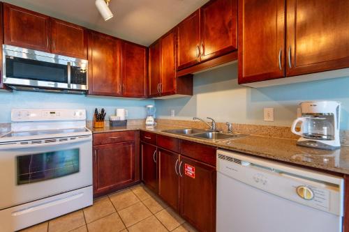 a kitchen with wooden cabinets and a white appliance at Laketown Wharf Condo beach view in Panama City Beach