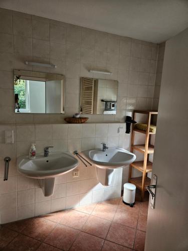Un baño con dos lavabos y un espejo. en Ganze Wohnung mit Garten, en Bremen