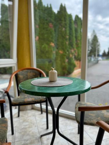 a green table with a candle on top of it at Marianna Apartman in Szentgotthárd