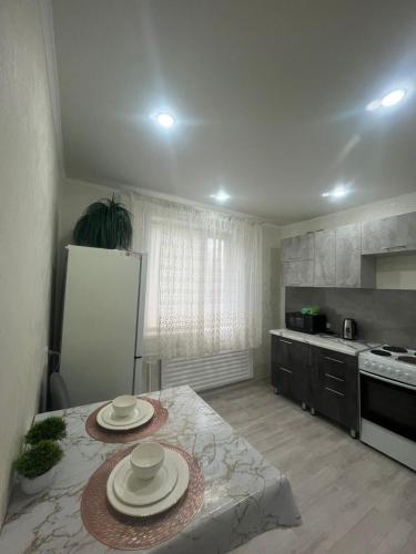 Una cocina con una mesa con dos platos encima. en Квартира, en Pavlodar