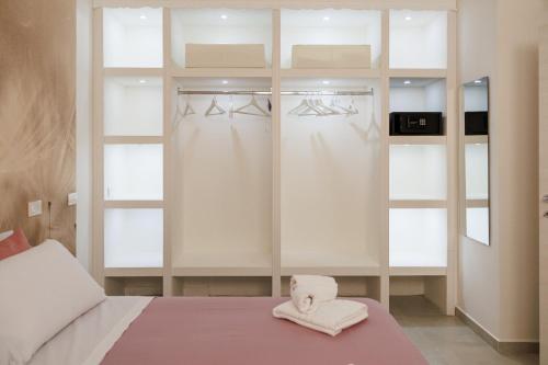 a bedroom with a bed with white sheets and towels at B Luxury Home in Castellammare di Stabia