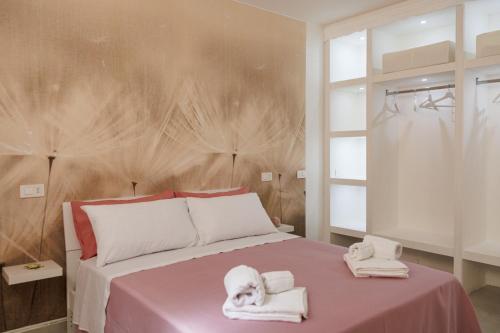 a bedroom with a pink bed with towels on it at B Luxury Home in Castellammare di Stabia