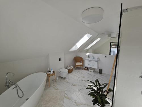 a bathroom with a bath tub and a toilet at W Tarczynach - mazurski dom z widokiem na jezioro in Tarczyny