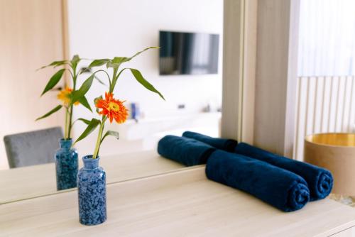 two blue vases with flowers in them on a table at Ozone Sky View Residence in Laguna Phuket