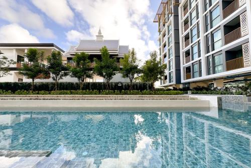 a swimming pool in front of a building at Ozone Sky View Residence in Laguna Phuket