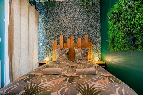 a bedroom with a bed with a green wall at Jungle - 4 pers- Sauna- Vidéoprojecteur - Terrasse in Libourne