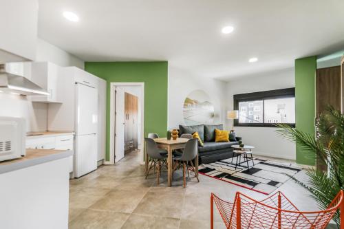 ベシンダリオにあるCity Hub Stayのソファとテーブルのあるキッチンとリビングルーム