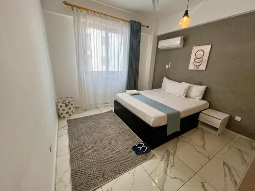 a small bedroom with a bed and a window at Seabreeze haven apartment in Mombasa