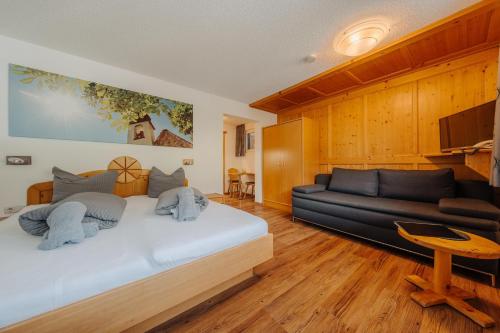 a bedroom with a large bed and a couch at Appartment Ganahl in Gaschurn