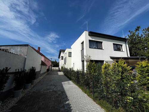a white building with a pathway in front of it at Malu Apartman in Sárvár