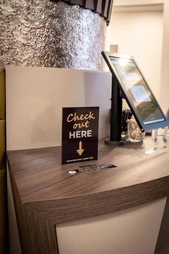 a counter with a sign that reads check just here at CHRIZZ Rooms in Graz