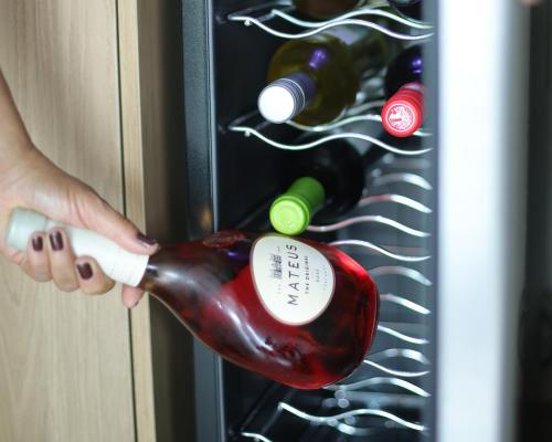 Eine Person, die eine Flasche Wein in einem Kühlschrank hält in der Unterkunft Ecos da Serra in Bezerros