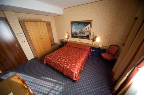 a hotel room with a red bed and a chair at Hotel Al Sole in Preganziol