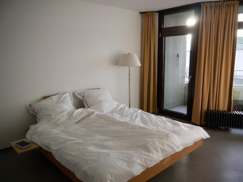 a bed with white sheets and pillows in a room at Urban Art Living - Your temporary home in Niederdorla