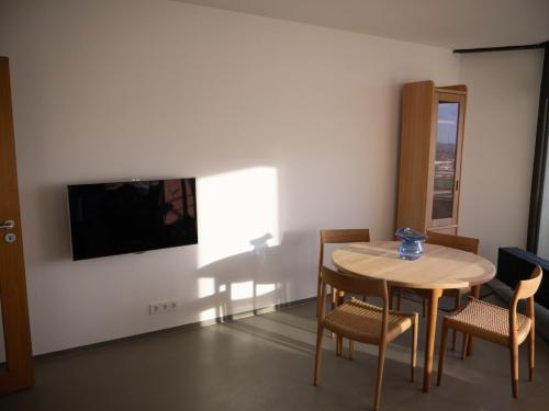 a dining room with a table and chairs and a television at Urban Art Living - Your temporary home in Niederdorla