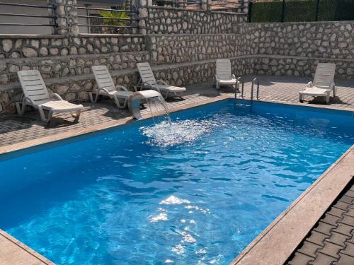 a pool with chairs and a water fountain at Çakıl suit otel restaurant in Merdivenlikuyu