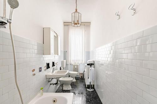 a white bathroom with two toilets and a sink at Casa Del Volo 10 Min Turin Airport & Juve Stadium in Borgaro Torinese