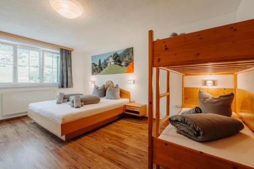 two bunk beds in a room with wooden floors at Appartment Ganahl in Gaschurn