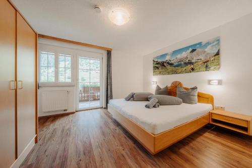 a bedroom with a bed and a large window at Appartment Ganahl in Gaschurn