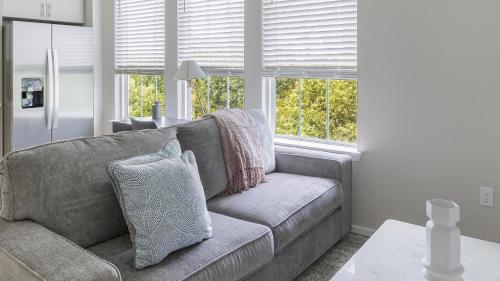 a living room with a couch and two windows at Landing Apartments near Sun City Center and Riverview in Wimauma