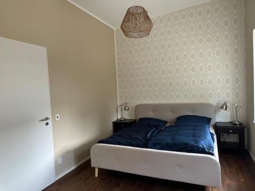 a bedroom with a bed with a blue blanket at Neubau FeWo in Haltern am See in Haltern