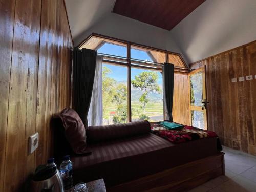 a room with a window and a couch in front of it at Ihab Villa Sembalun by RHM Indonesia in Sembalun Lawang