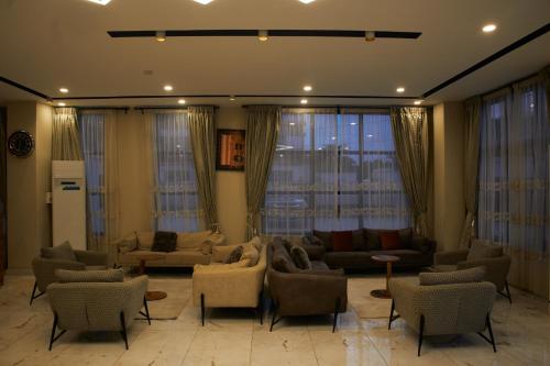 a living room with couches and chairs and windows at TWINS RESIDENCE Niamey in Niamey