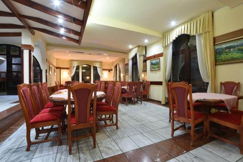 a dining room with tables and chairs in a restaurant at Vila Mina in Zlatibor