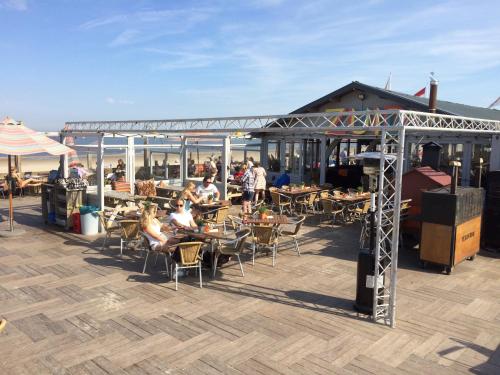 a group of people sitting at tables on a patio at Sea & Dunes in Scheveningen
