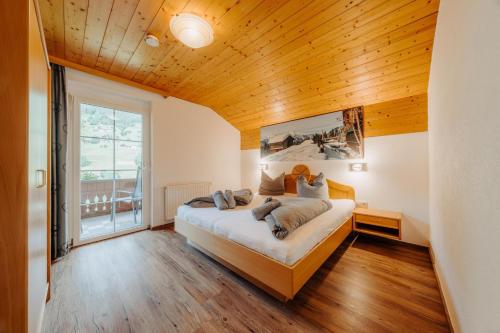 a bedroom with a large bed with a wooden ceiling at Appartment Ganahl in Gaschurn