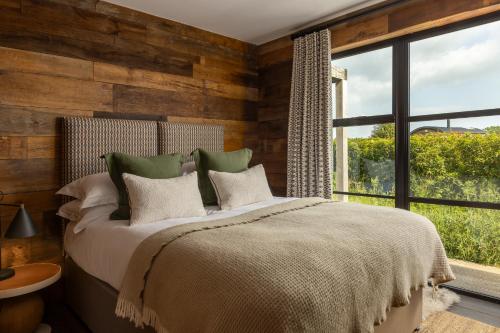 a bedroom with a bed and a large window at Louma Country Hotel in Wootton Fitzpaine